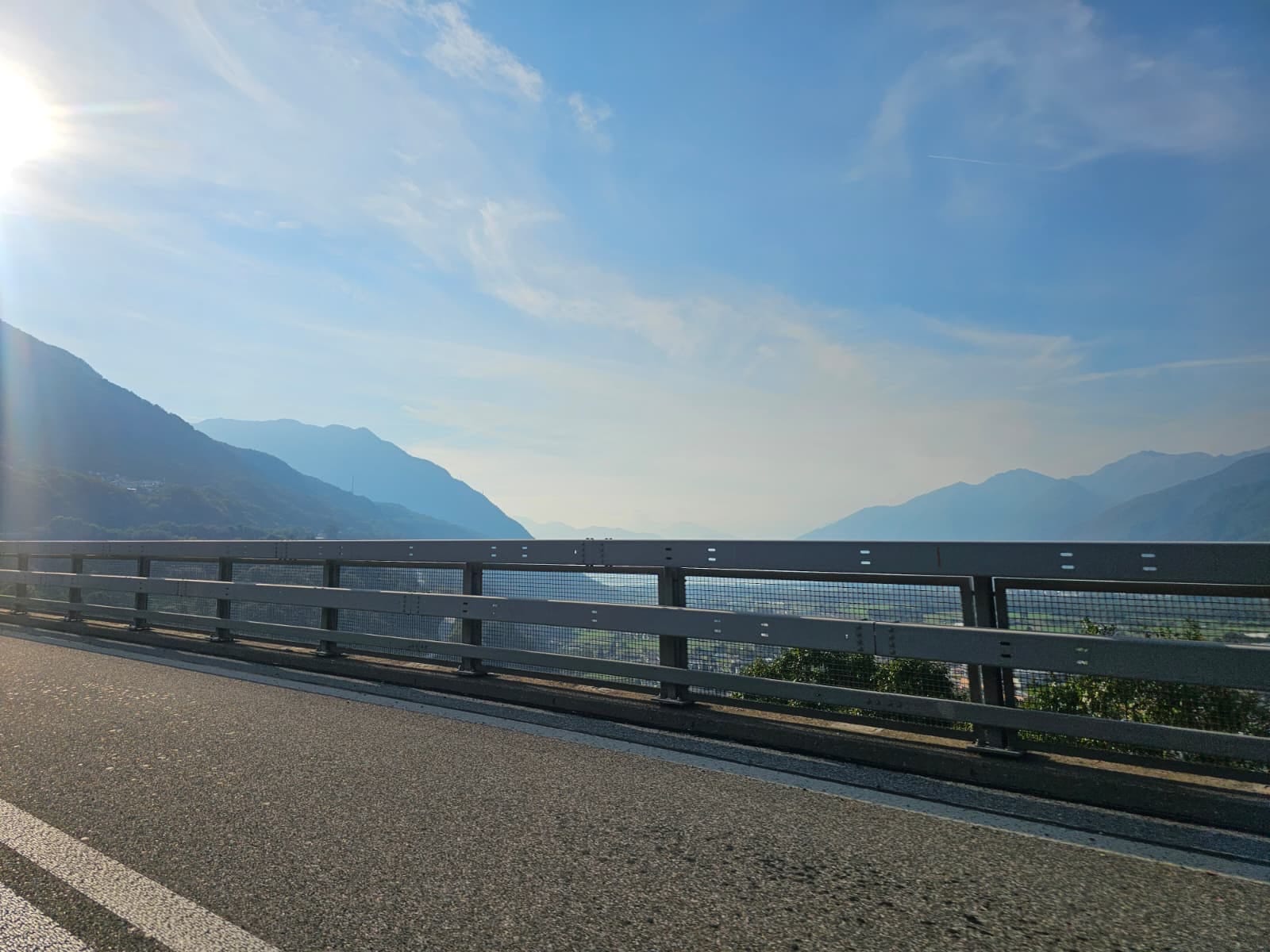 Blick von der Autobahn über ein weites Alpental im Dunst