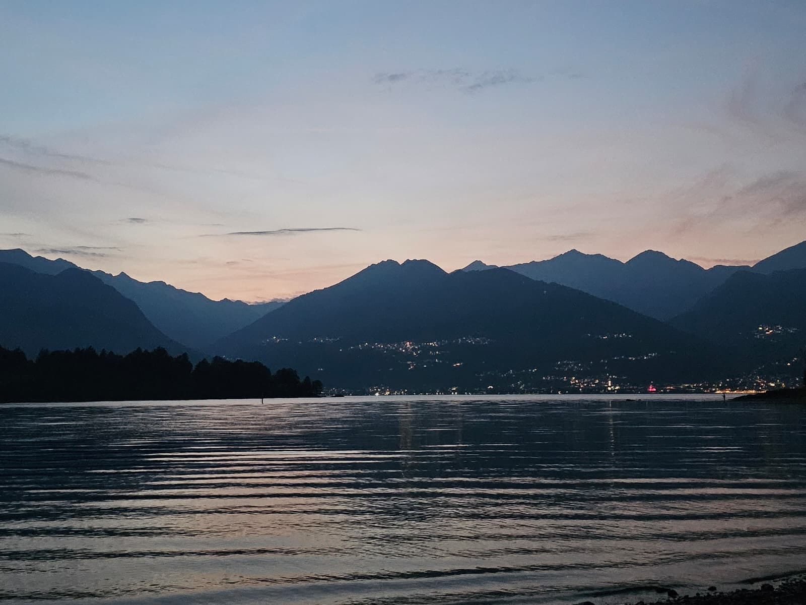Der See in der Dämmerung, Berge als Silhouette, Lichter am Ufer