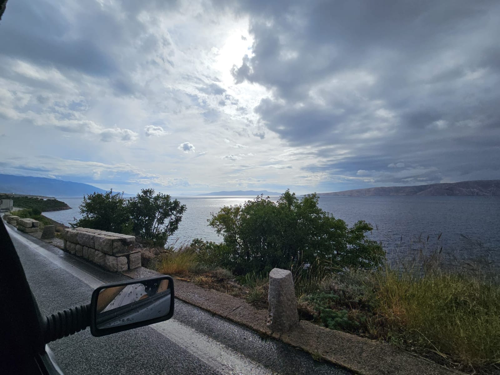 Nach dem Gewitter: nasse Straße, Wolken und ein bisschen Sonne über der Adria